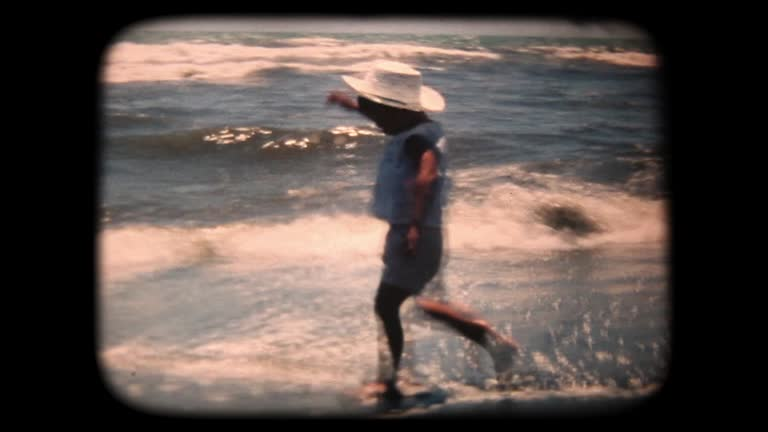 Person in shallow waves, grainy film still in a dark frame